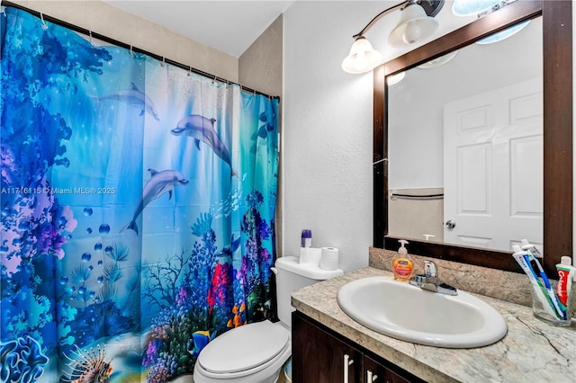 bathroom featuring a shower with curtain, vanity, and toilet