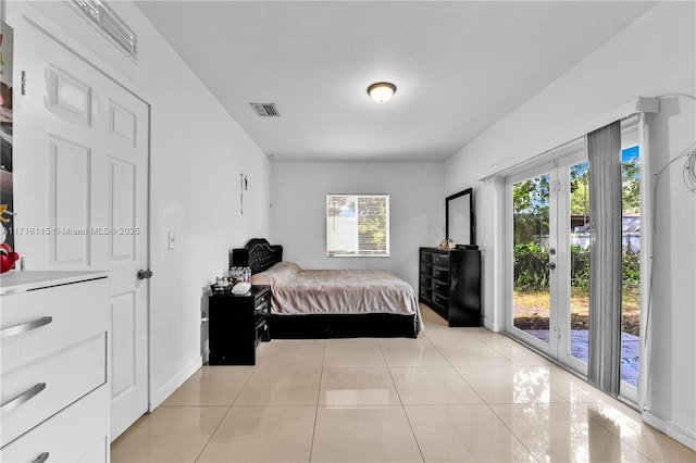 bedroom with access to exterior and light tile patterned floors