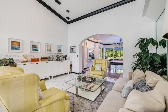 living room featuring crown molding, a towering ceiling, and light tile patterned floors