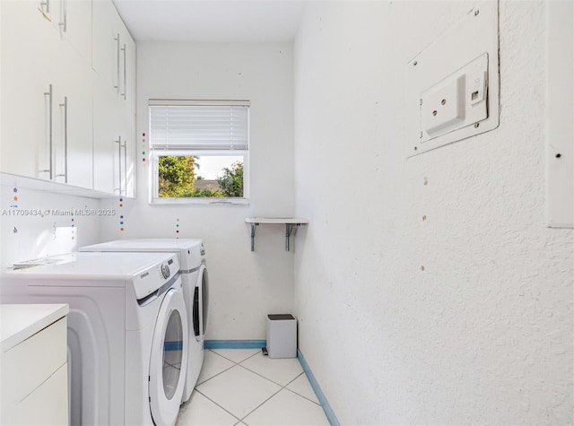 laundry room featuring cabinets, washing machine and dryer, and light tile patterned floors