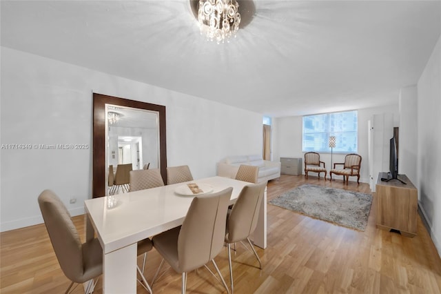 dining room with a chandelier and light hardwood / wood-style flooring