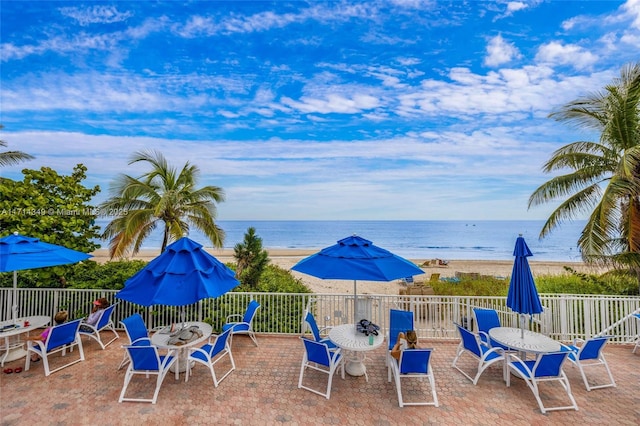 view of patio / terrace with a water view and a view of the beach