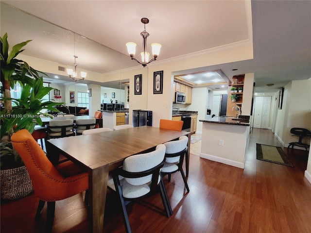 dining space with crown molding, sink, dark wood-type flooring, and a notable chandelier