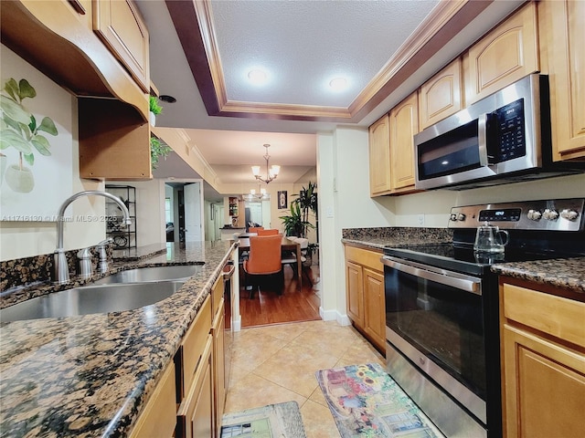 kitchen featuring stainless steel appliances, a raised ceiling, crown molding, sink, and a chandelier