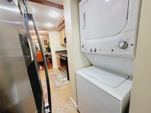 laundry room with a textured ceiling, crown molding, light tile patterned floors, and stacked washer and clothes dryer