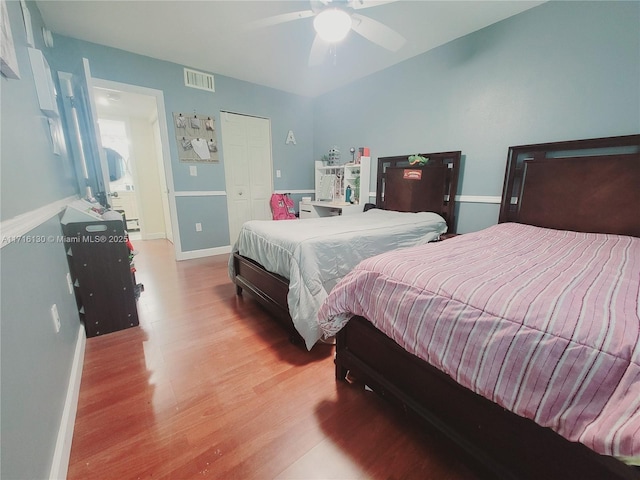 bedroom featuring hardwood / wood-style flooring, ceiling fan, and a closet