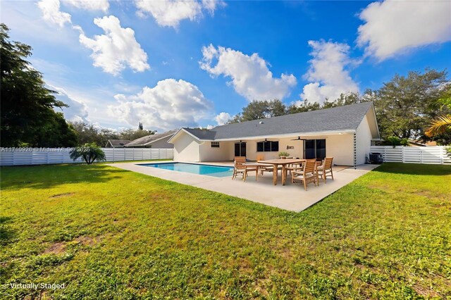 rear view of property featuring ceiling fan, a fenced in pool, a yard, and a patio