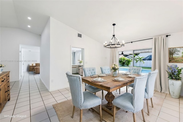 dining space featuring lofted ceiling, an inviting chandelier, and light tile patterned flooring