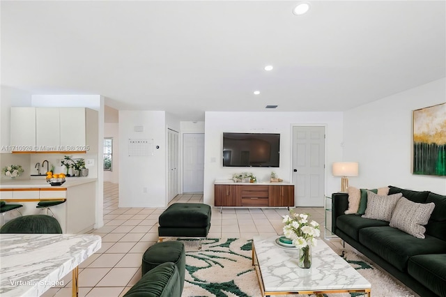 living room featuring sink and light tile patterned floors