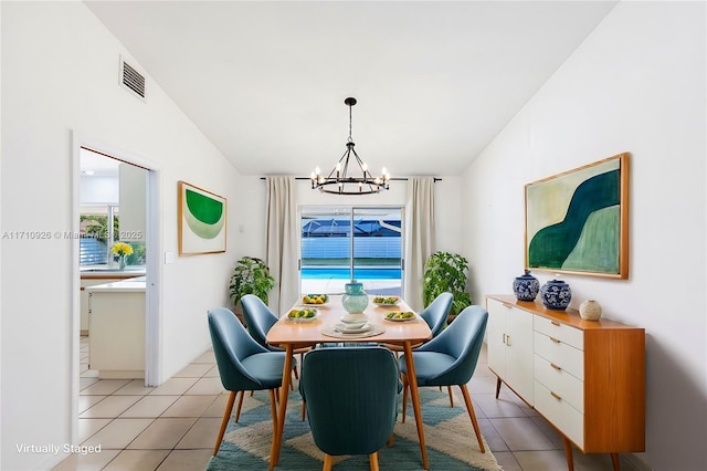 tiled dining area featuring lofted ceiling and a chandelier