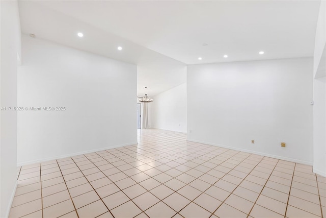 tiled spare room featuring lofted ceiling and an inviting chandelier