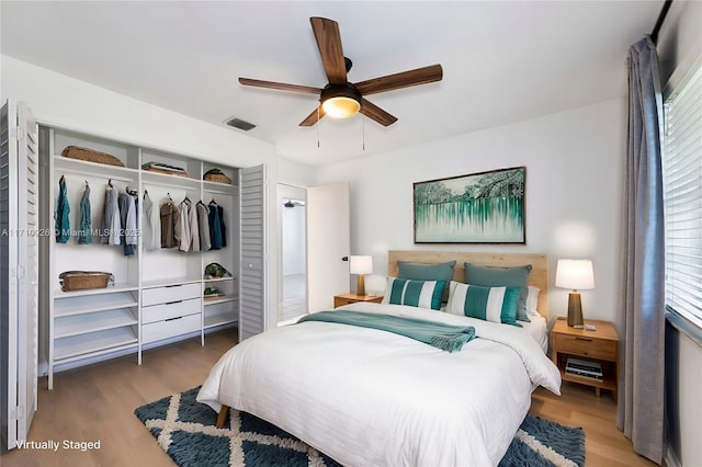 bedroom with dark hardwood / wood-style flooring, multiple windows, a closet, and ceiling fan