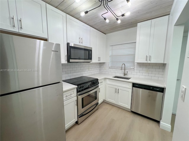 kitchen featuring stainless steel appliances, sink, light hardwood / wood-style flooring, wooden ceiling, and white cabinetry