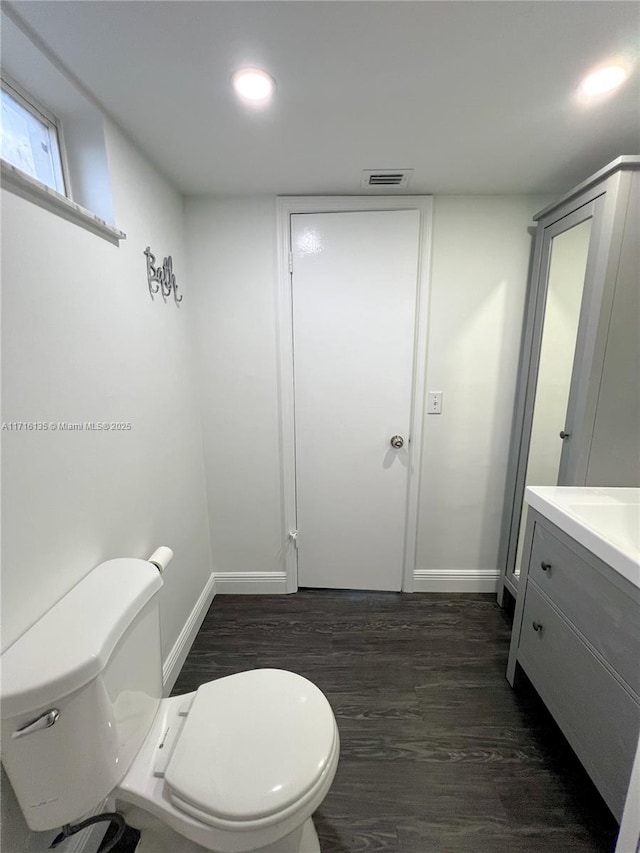 bathroom featuring vanity, hardwood / wood-style flooring, and toilet