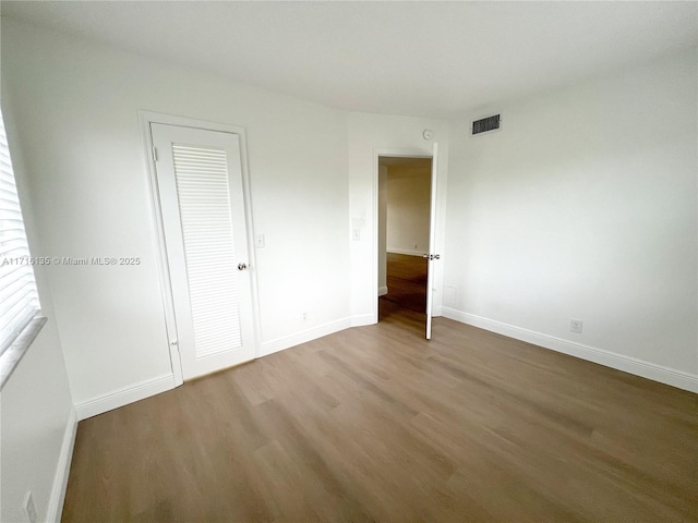 unfurnished bedroom with a closet and wood-type flooring