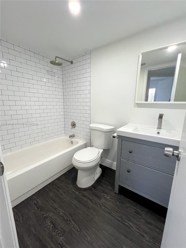 full bathroom with toilet, vanity, wood-type flooring, and tiled shower / bath