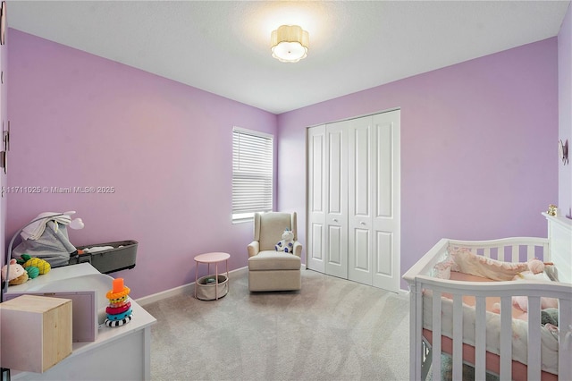 carpeted bedroom with a closet and a crib