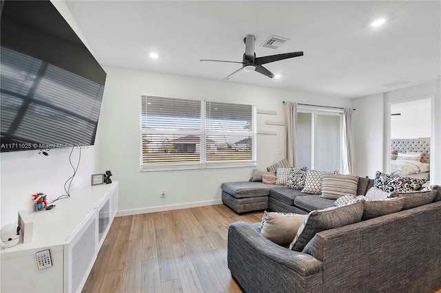 living room featuring ceiling fan and light hardwood / wood-style floors