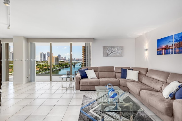 living room with a water view, light tile patterned flooring, and rail lighting