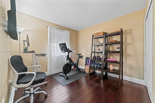 exercise area featuring dark hardwood / wood-style floors and a textured ceiling