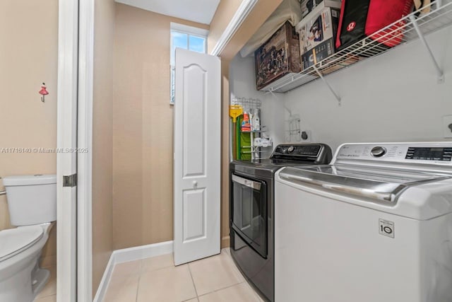 washroom featuring light tile patterned floors and washing machine and clothes dryer