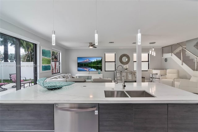 kitchen with dark brown cabinets, sink, stainless steel dishwasher, and decorative light fixtures