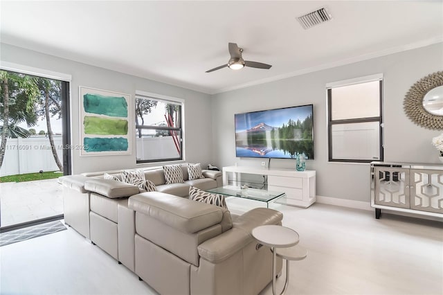 living room with ceiling fan and crown molding