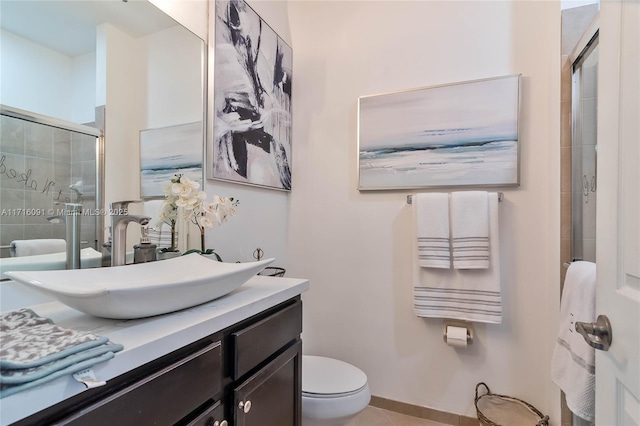 bathroom featuring vanity, toilet, and a shower with shower door