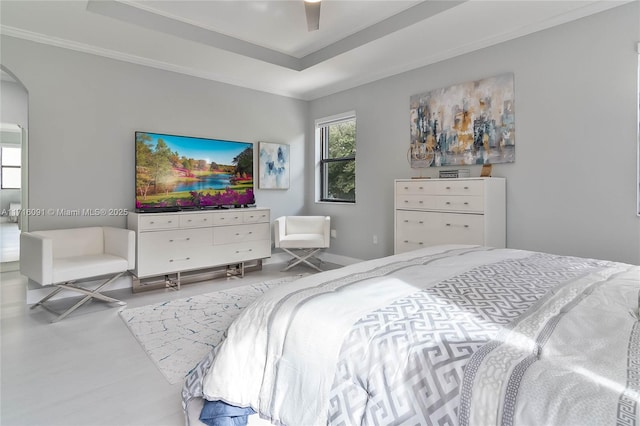 bedroom featuring ceiling fan, a raised ceiling, and ornamental molding