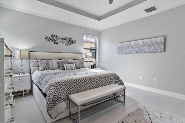 bedroom featuring ceiling fan, ornamental molding, and a tray ceiling