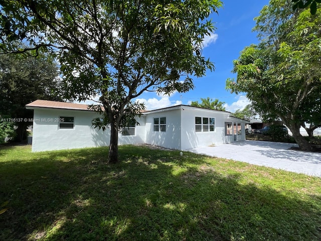 rear view of property with a yard and a patio area