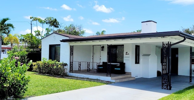 view of front of property with a carport, covered porch, and a front yard