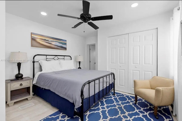 bedroom featuring ceiling fan, light hardwood / wood-style floors, and a closet