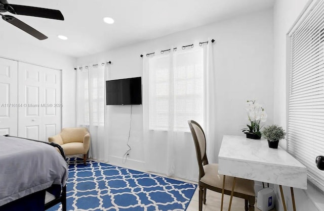 bedroom featuring ceiling fan, a closet, and multiple windows