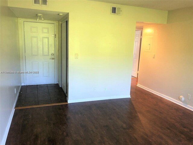 unfurnished room with dark hardwood / wood-style flooring