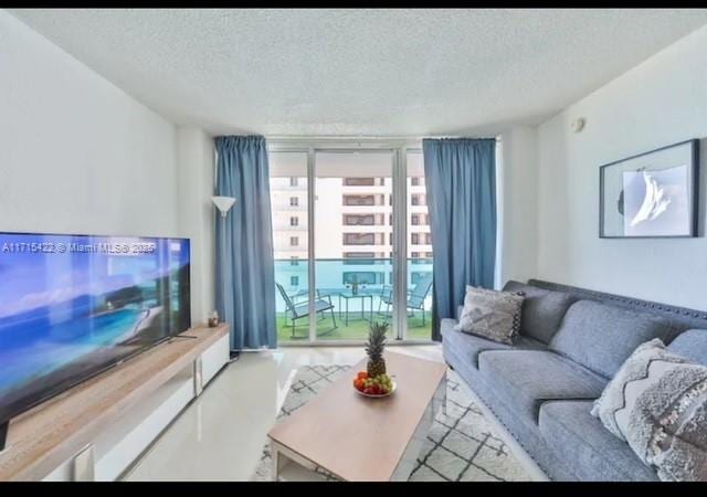 living room with a textured ceiling and a wall of windows