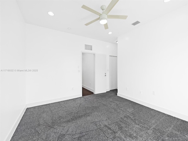 unfurnished bedroom with baseboards, visible vents, dark carpet, and recessed lighting