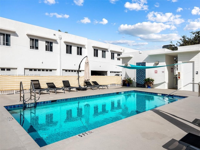 community pool with a patio and fence