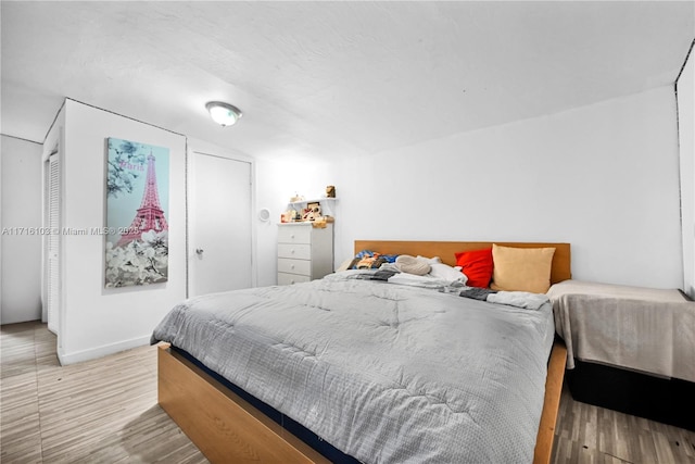 bedroom featuring wood-type flooring and lofted ceiling