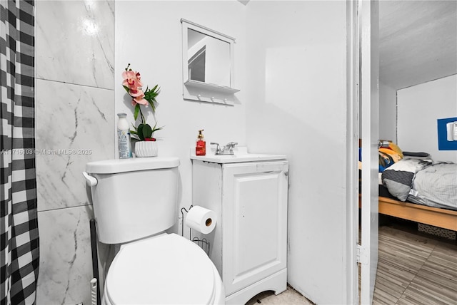 bathroom featuring walk in shower, vanity, and toilet