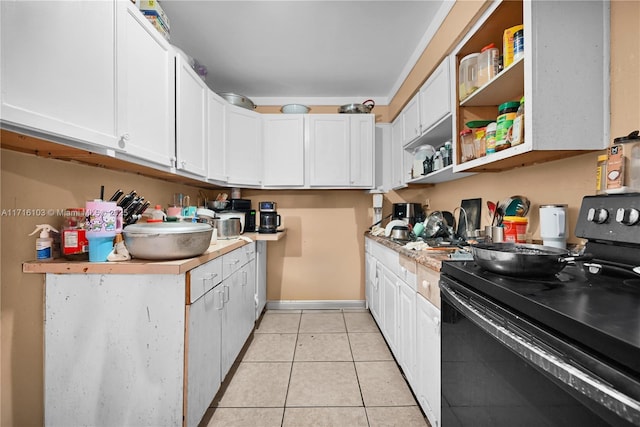 kitchen with black / electric stove, white cabinetry, and light tile patterned floors