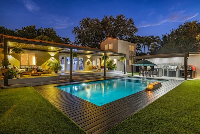 pool at dusk with a yard, area for grilling, and a patio area