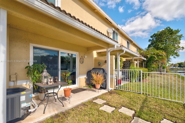 entrance to property with central AC, a yard, and a patio