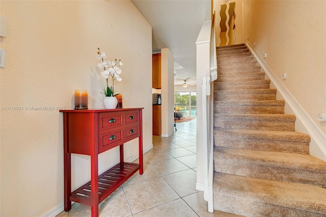 stairs with tile patterned floors and ceiling fan