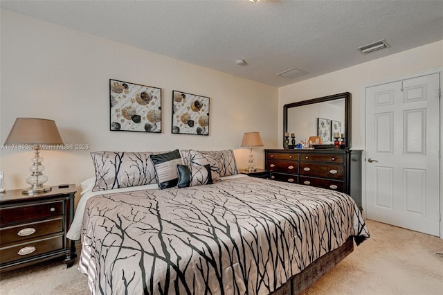 bedroom featuring a textured ceiling and light carpet