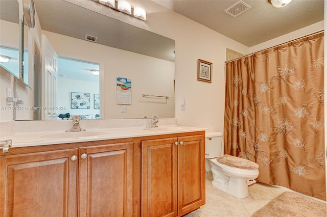 bathroom with vanity, tile patterned flooring, a shower with shower curtain, toilet, and a textured ceiling