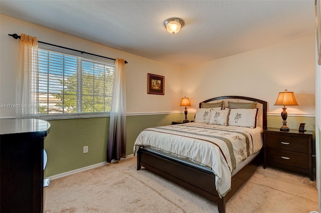 bedroom featuring light colored carpet and a textured ceiling