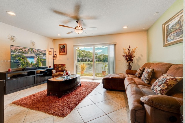 tiled living room with a textured ceiling and ceiling fan