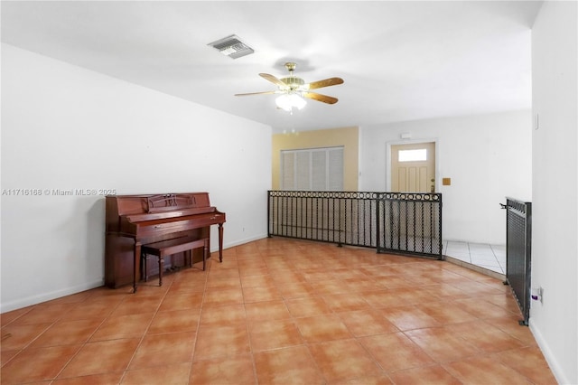 interior space with light tile patterned floors and ceiling fan