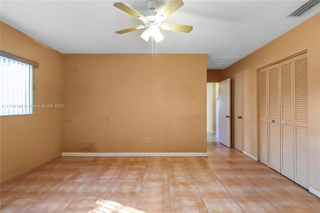 interior space featuring ceiling fan, light tile patterned floors, and a closet